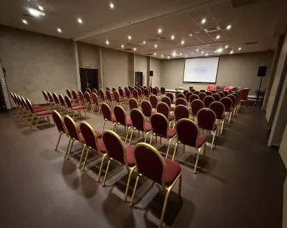 Konferenzraum ähnlich dem Modell 3 im Mahogany Hôtel Résidence & Spa, Le Gosier, Guadeloupe, mit violetten Stühlen und Projektor.