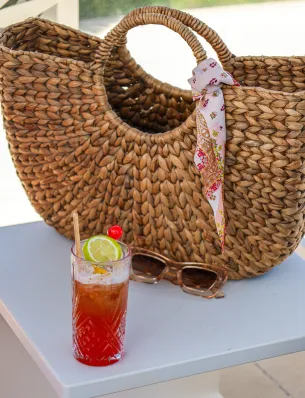 Kellner serviert Cocktails an eine Kundin auf einer Sonnenliege am Meer im Hotel Résidence & Spa Mahogany, Le Gosier, Guadeloupe.