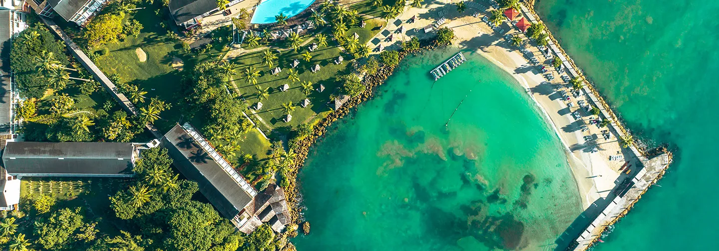 Palmeraie luxuriante encadrant une vue splendide sur le lagon cristallin au Mahogany Hôtel, Le Gosier.