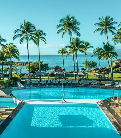 Vue panoramique sur la piscine, le jardin tropical et l'océan au Mahogany Hôtel Résidence & Spa