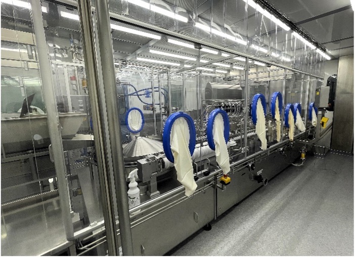 Aseptic filling line isolator with a row of blue-rimmed glove ports along a stainless steel enclosure