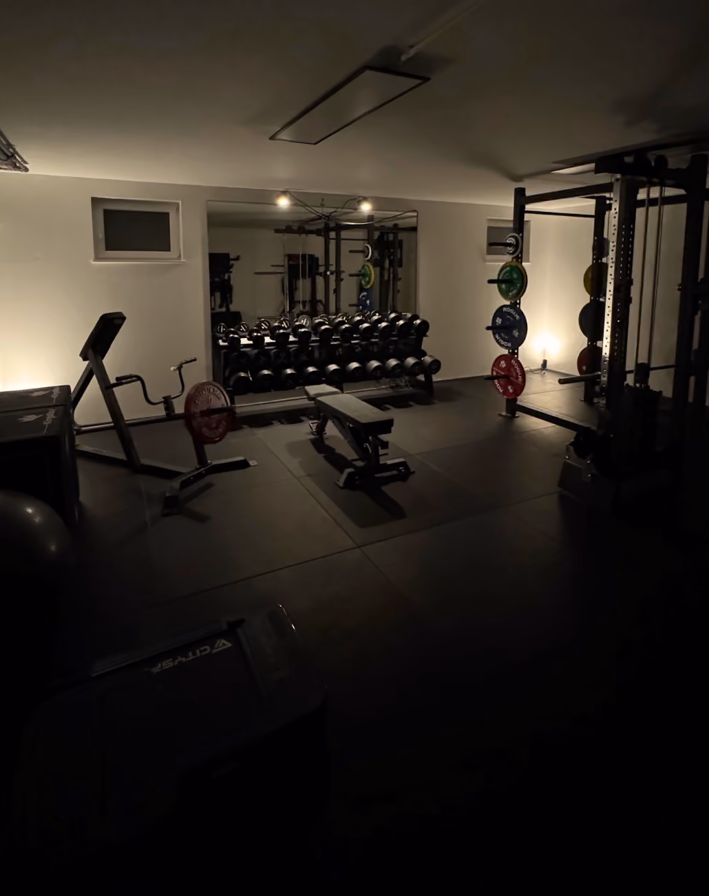 Ein voll ausgestattetes Homegym in einem dunklen Setting