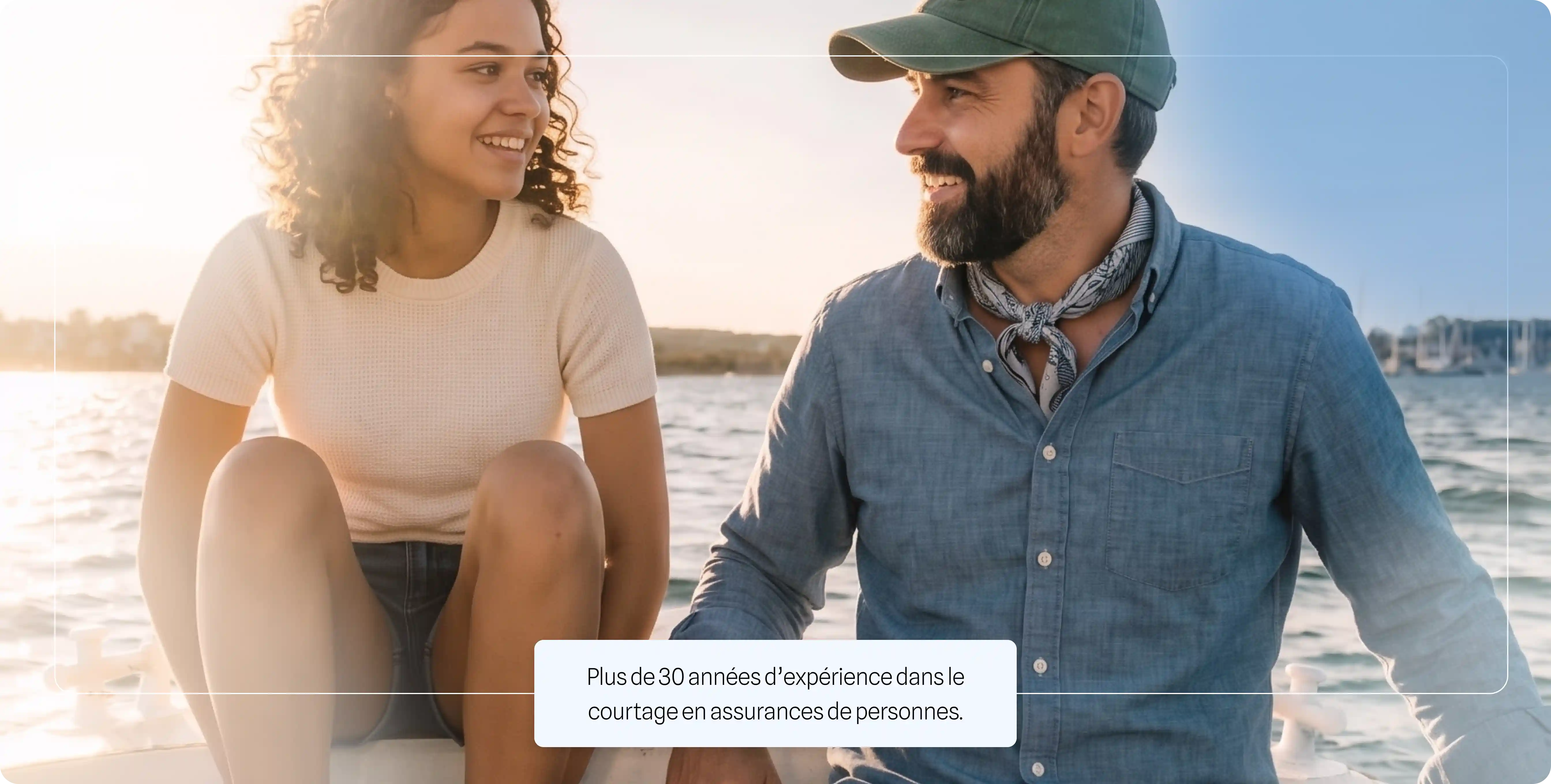Jeune femme souriante et homme barbu parlant sur un bateau au coucher du soleil.