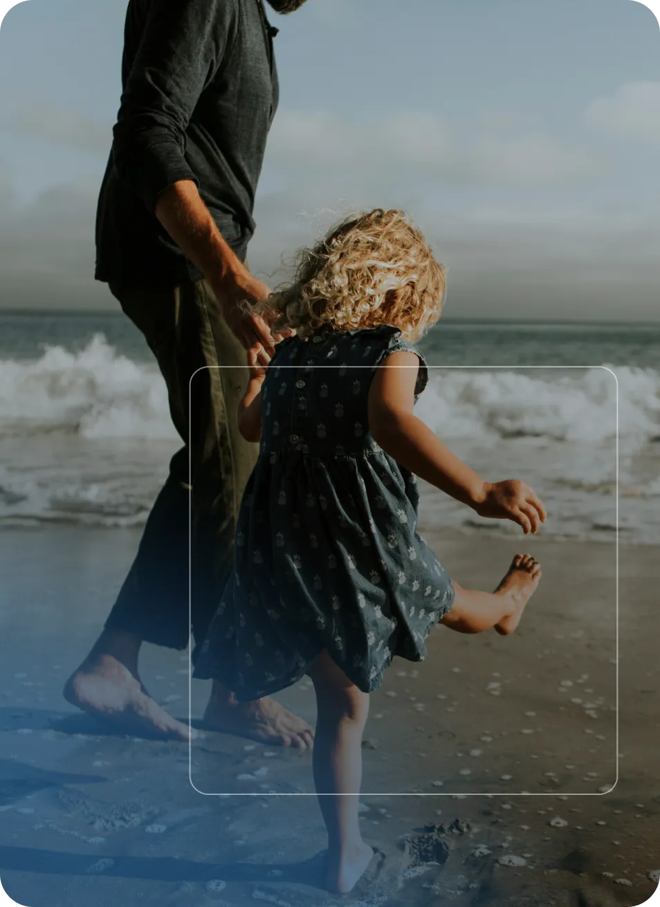 Un adulte et une enfant marchent pieds nus sur la plage près des vagues.