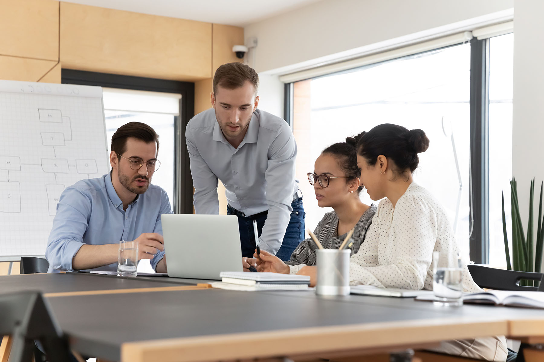 Small marketing team reviewing work together on a laptop