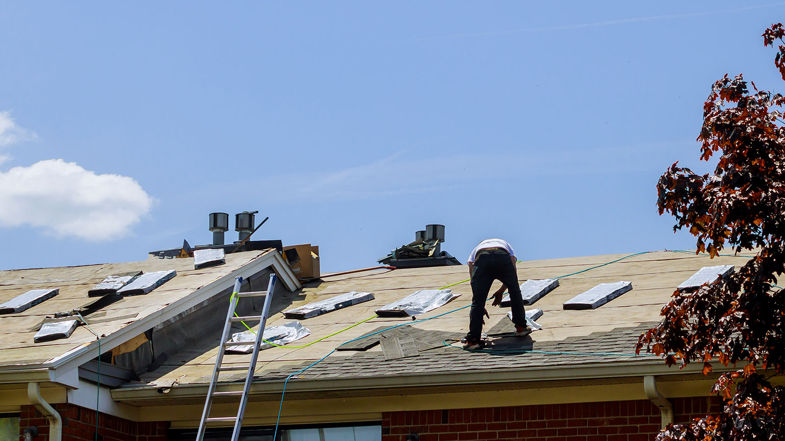 Roofing contractor replacing shingles on a residential roof in Florida