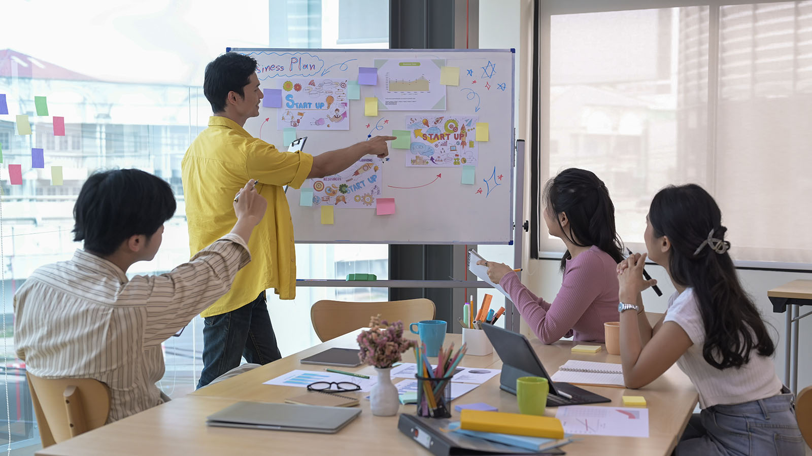 Marketing team working through a strategy session at a whiteboard