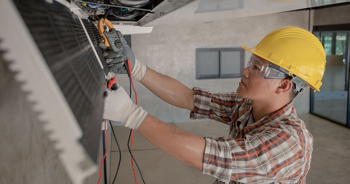 HVAC technician testing an indoor air conditioning unit with a meter in a South Tampa home