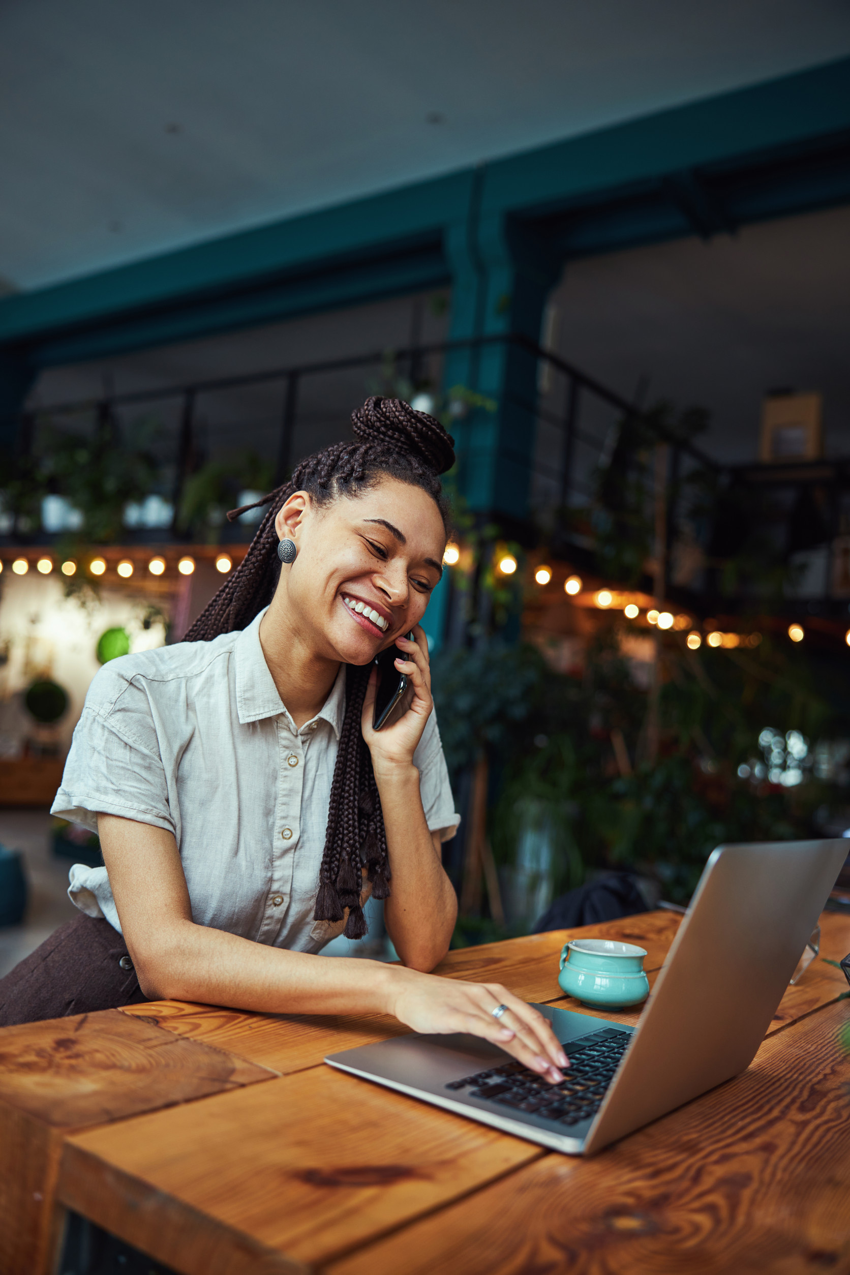 Smiling business owner taking a customer call at her laptop