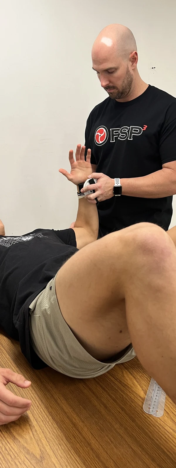 PSP3 coach performing a hands-on movement assessment with an athlete