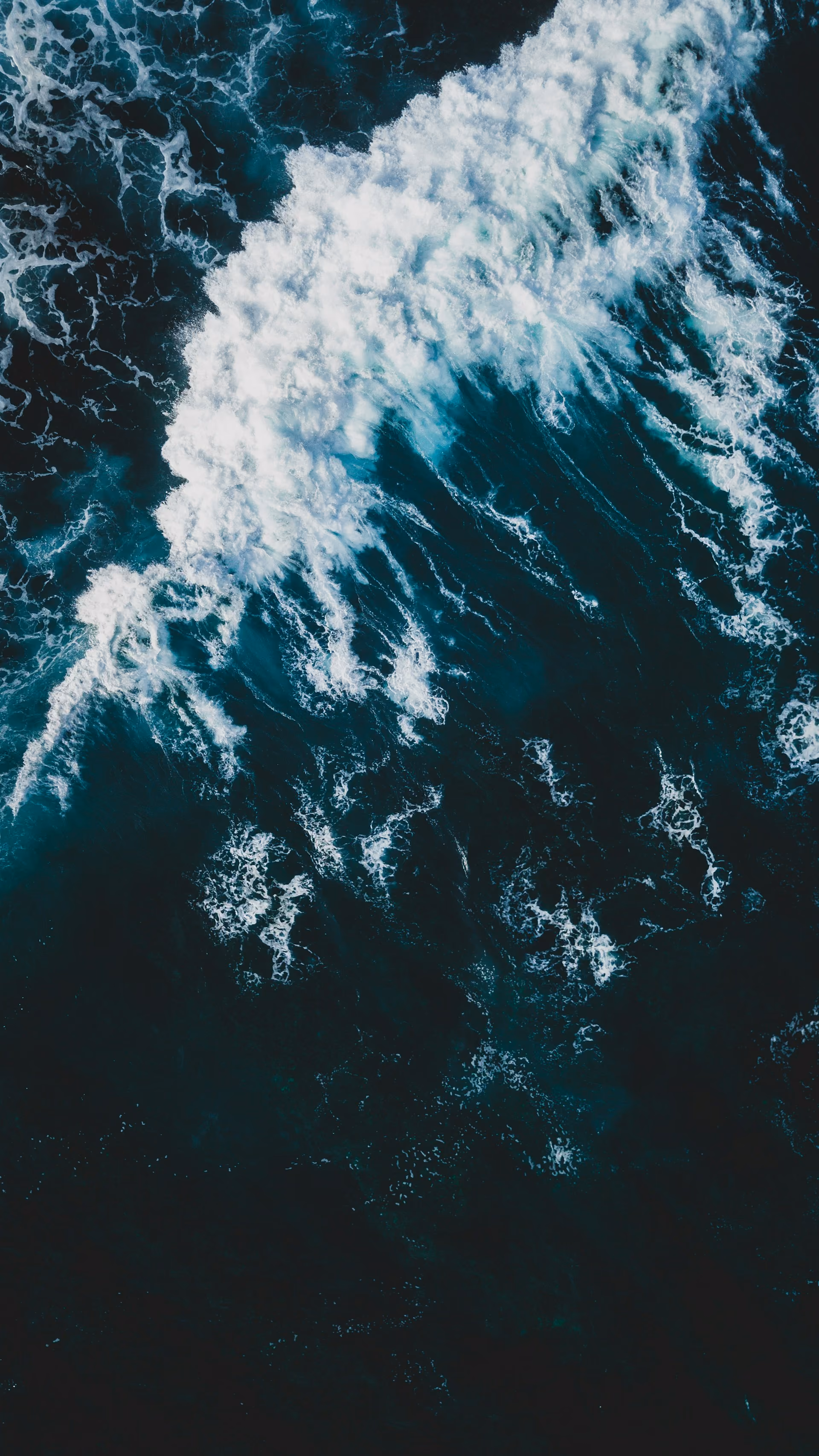 Vue aérienne des vagues puissantes déferlant sur l'océan sombre.