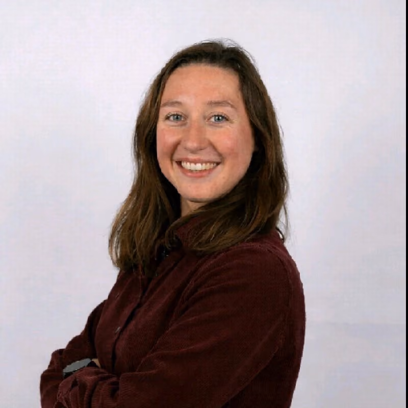 Photo portrait d'une femme à 3 quart, avec un visage souriant et une posture professionnelle