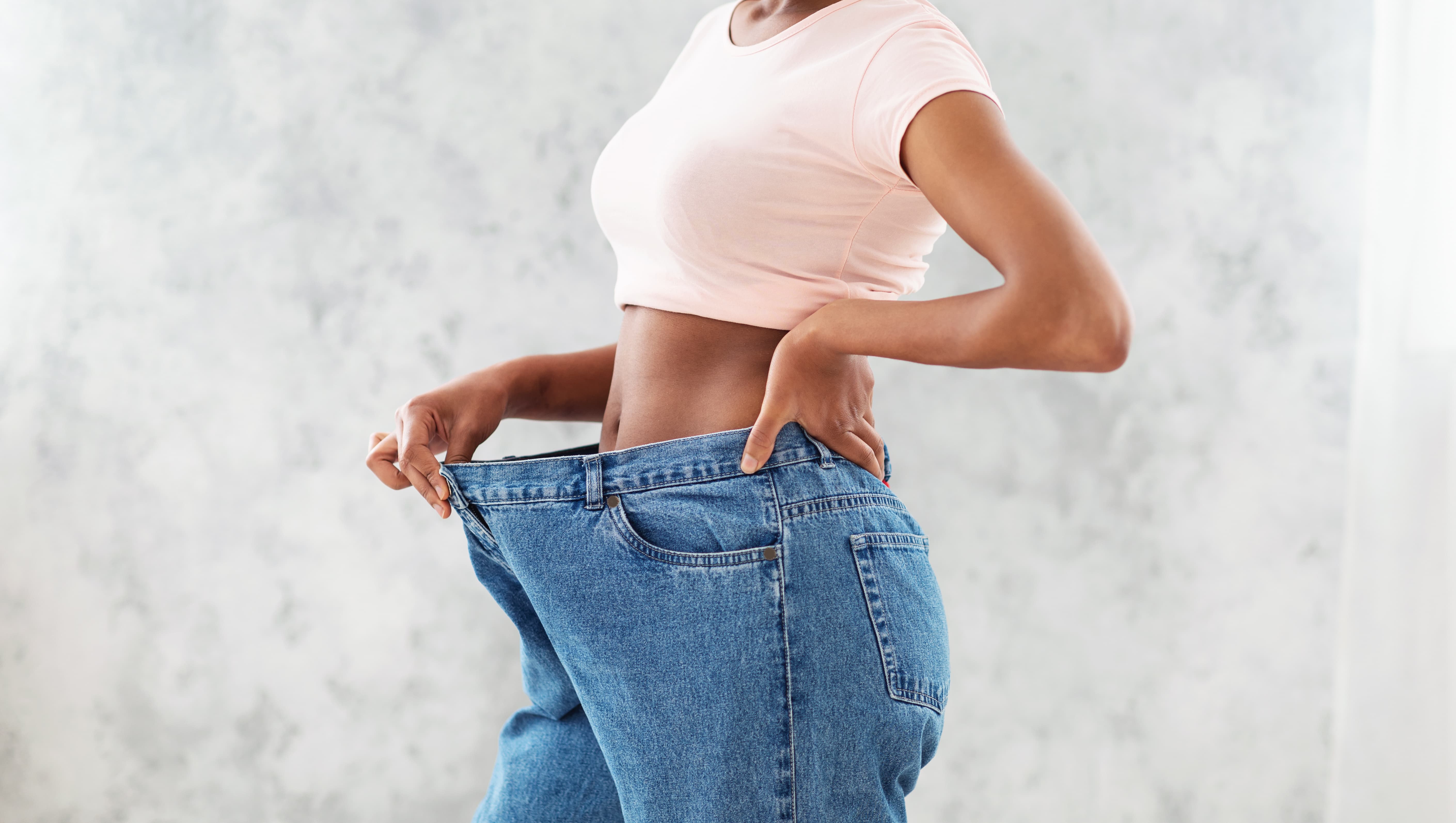 Woman measuring her waist during a medical weight loss program