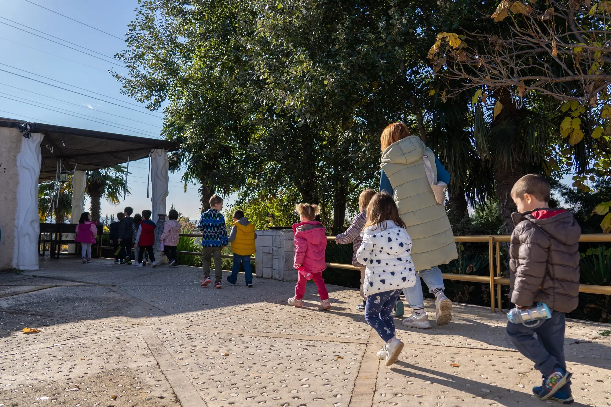 Παιδιά περπατούν με εκπαιδευτικό στον εξωτερικό χώρο του The Key Creative School