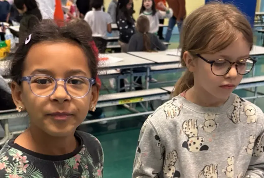 Two elementary students wearing glasses at a school event