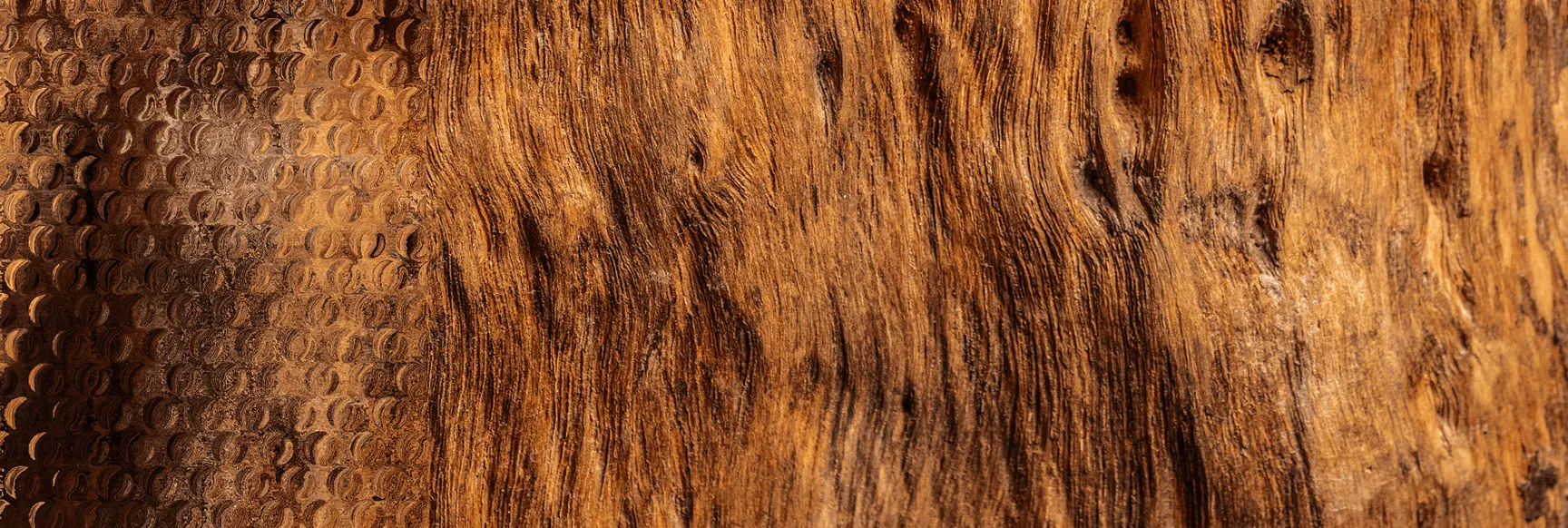 Close-up of textured wooden surface with worn, grooved patterns and a honeycomb-like section on the left.