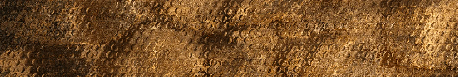 Textured close-up of an embossed, antique bronze metal surface with a repeating circular pattern.