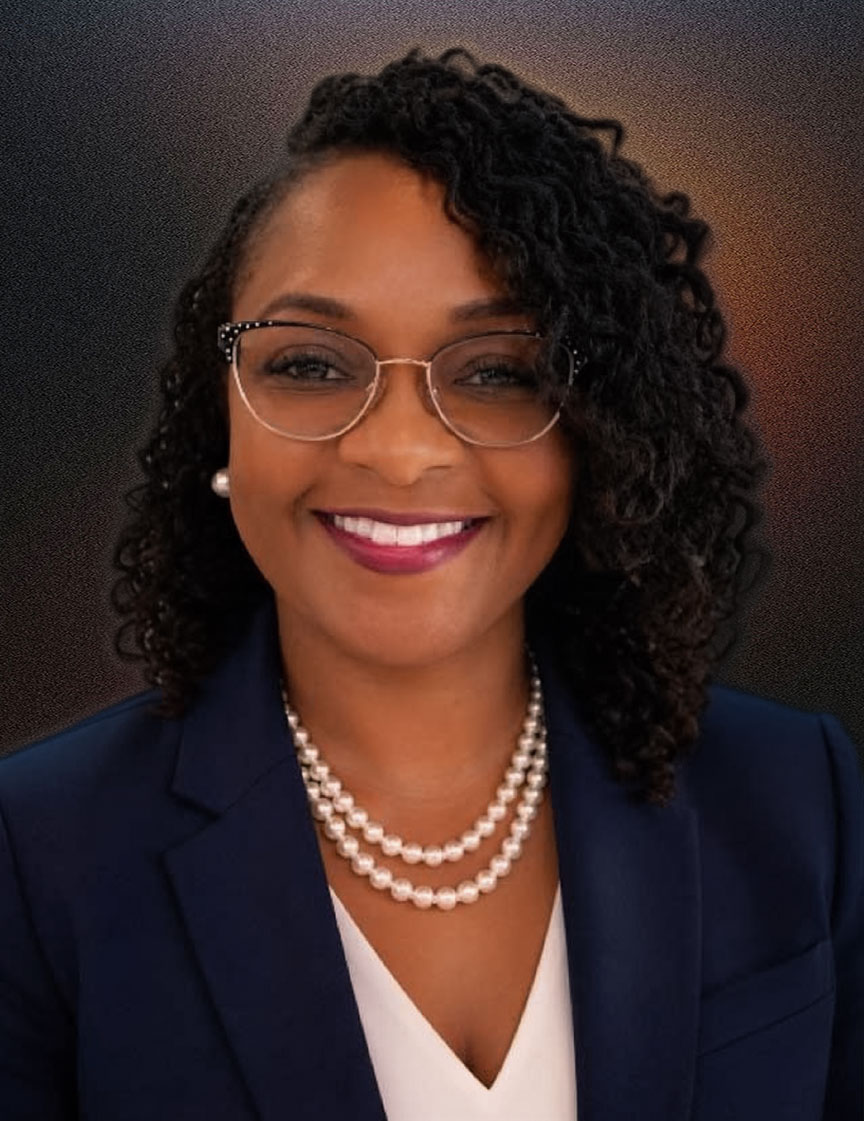 Portrait of a smiling woman with curly hair wearing glasses, pearl earrings, a double strand pearl necklace, a white top, and a navy blazer.
