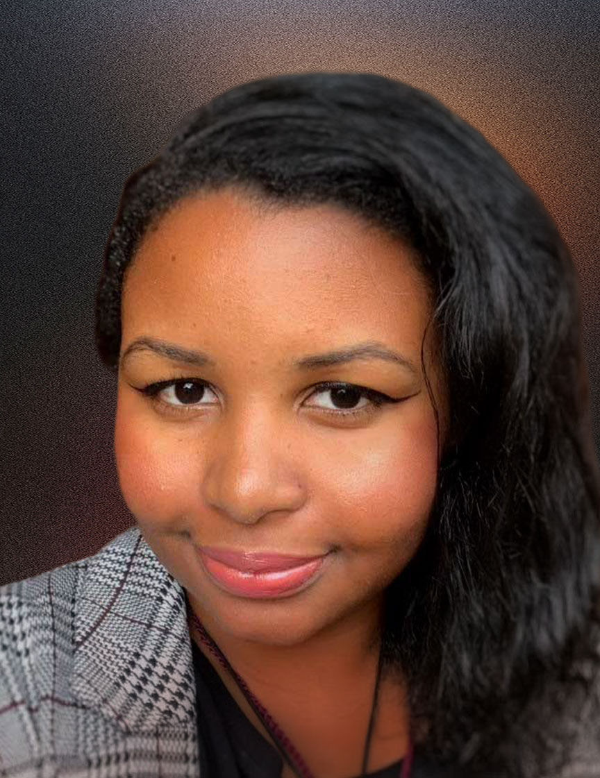 Close-up portrait of a woman with smooth dark hair swept to one side, natural makeup with winged eyeliner and pink lipstick, wearing a patterned jacket over a black top, smiling gently in warm indoor lighting.
