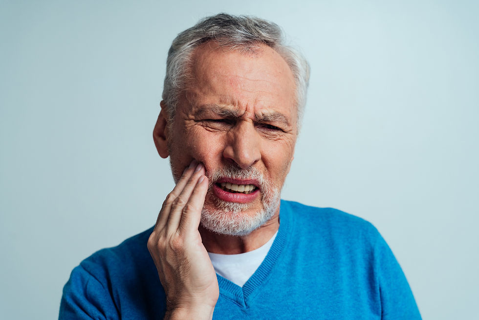 Elderly man in blue sweater winces in pain from tooth sensitivity, a manageable oral health condition that patients should discuss with Dr. Dave Cutts, dentist in Temecula, CA