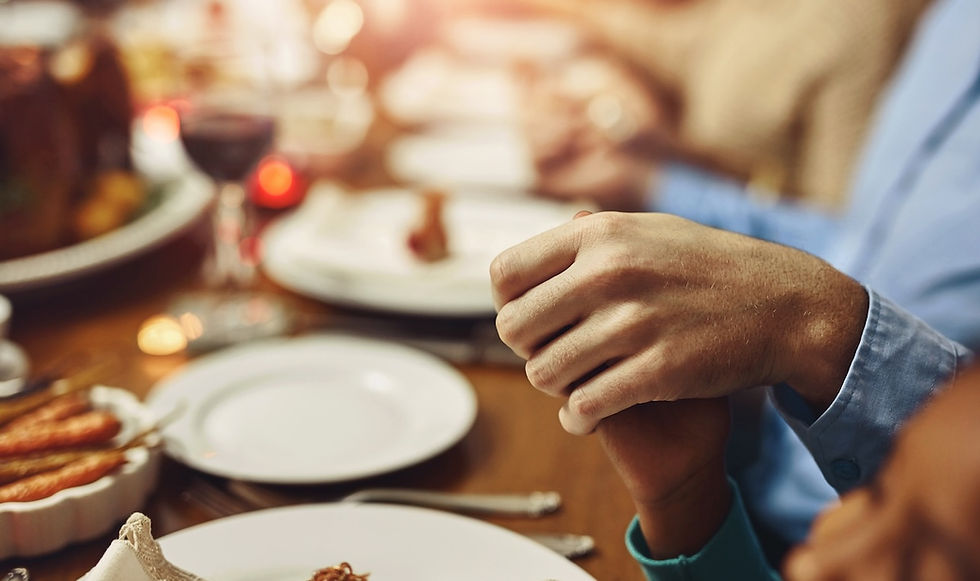 family holding hands at a Christmas dinner table