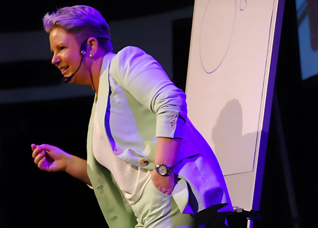 Jackie Handy engaging conference audience on stage as a leadership and workplace culture speaker