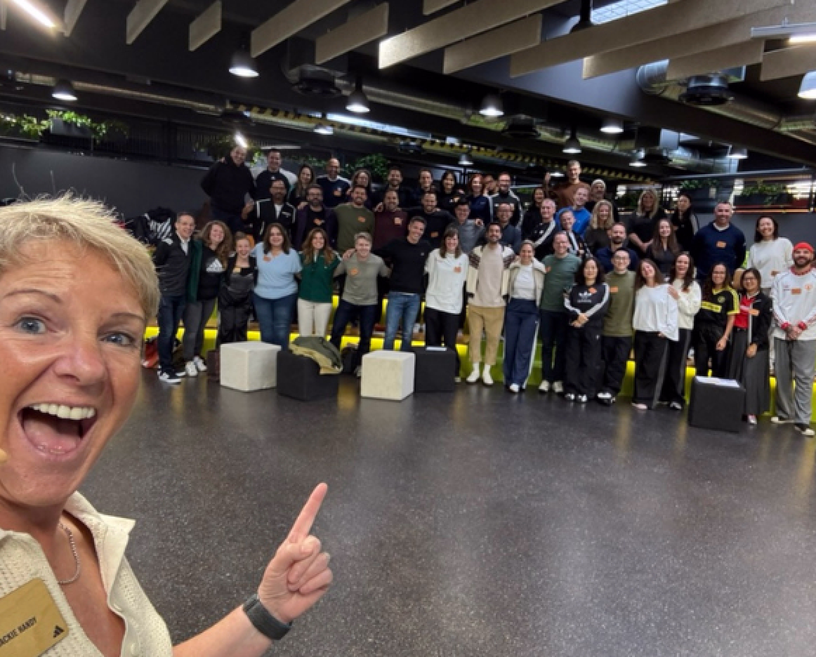 Jackie Handy smiling with a large group of delegates after a leadership training workshop.