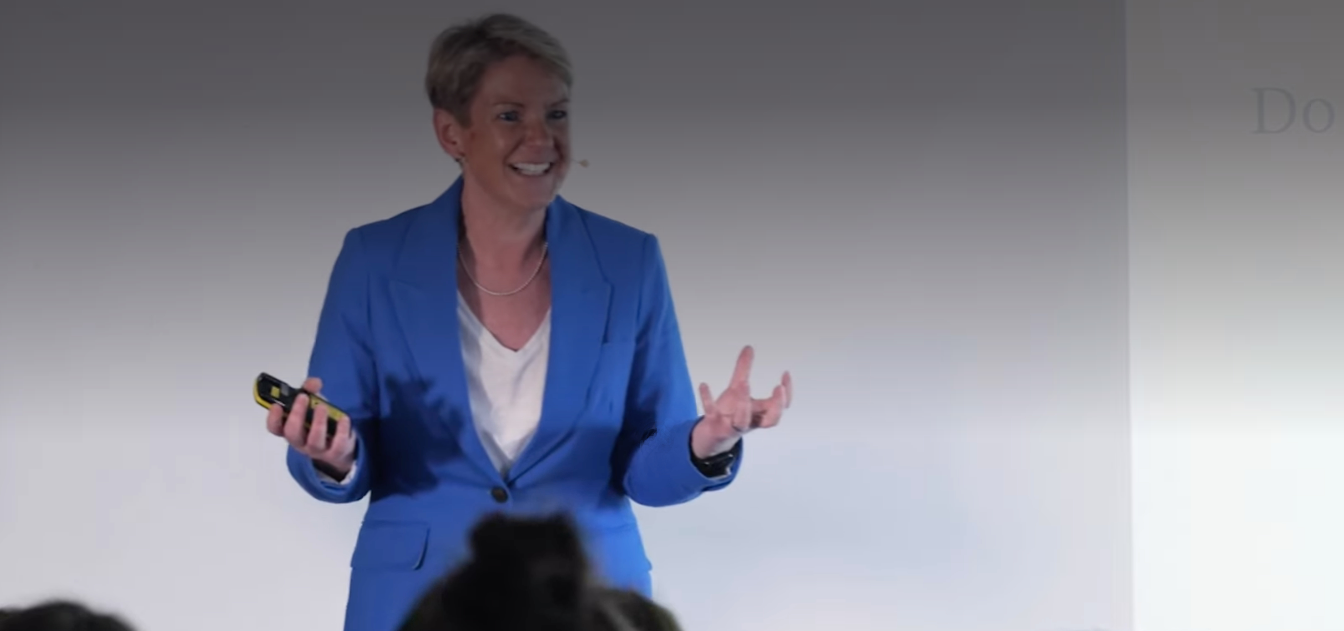 Jackie Handy speaking on stage delivering a keynote presentation.