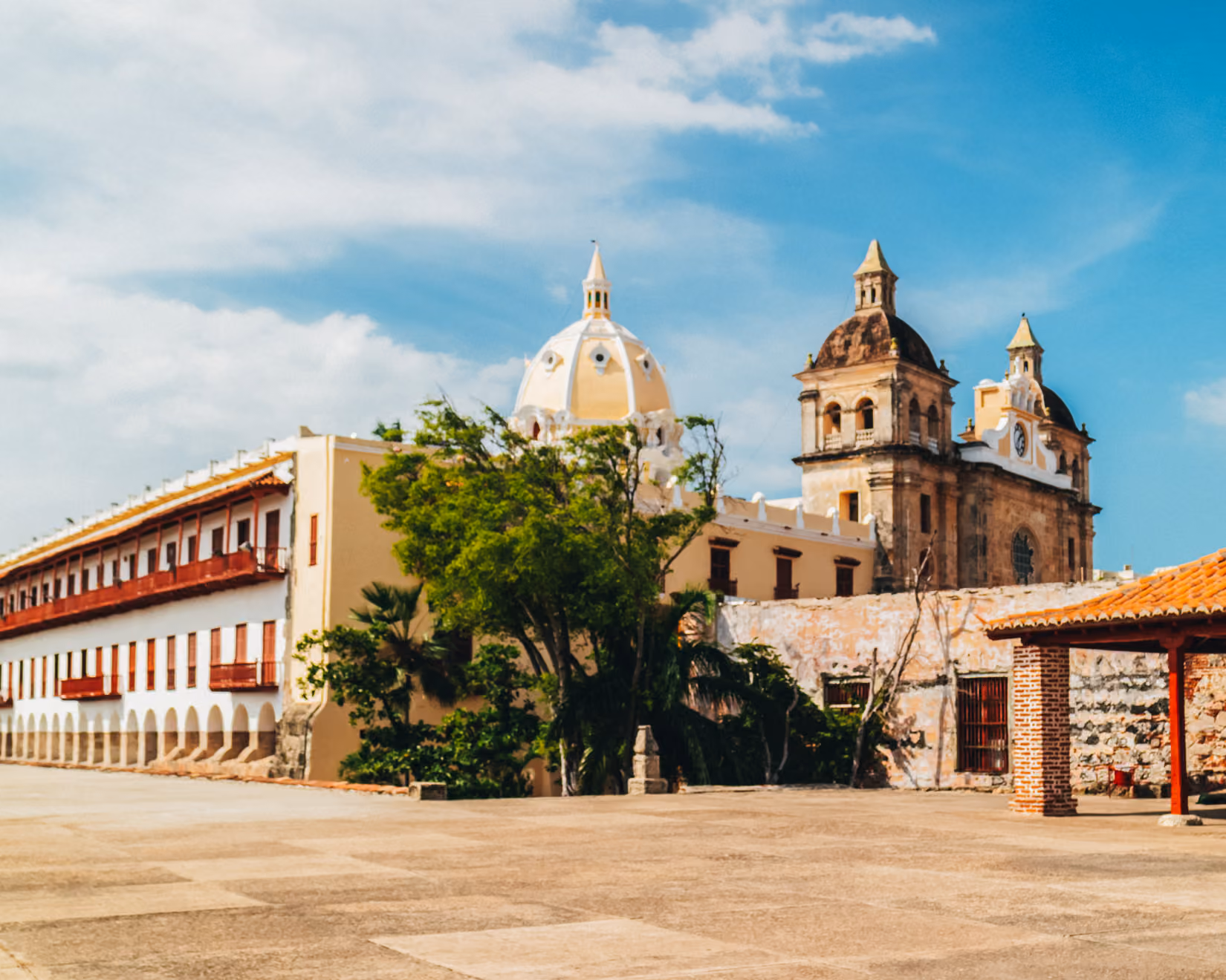 Historic buildings with domes and arches under a partly cloudy blue sky.