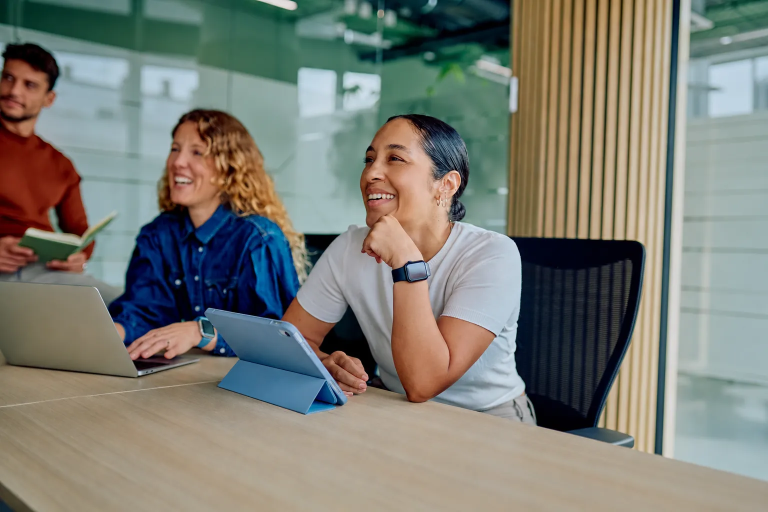 Colleagues smiling during a strategy session around a conference table