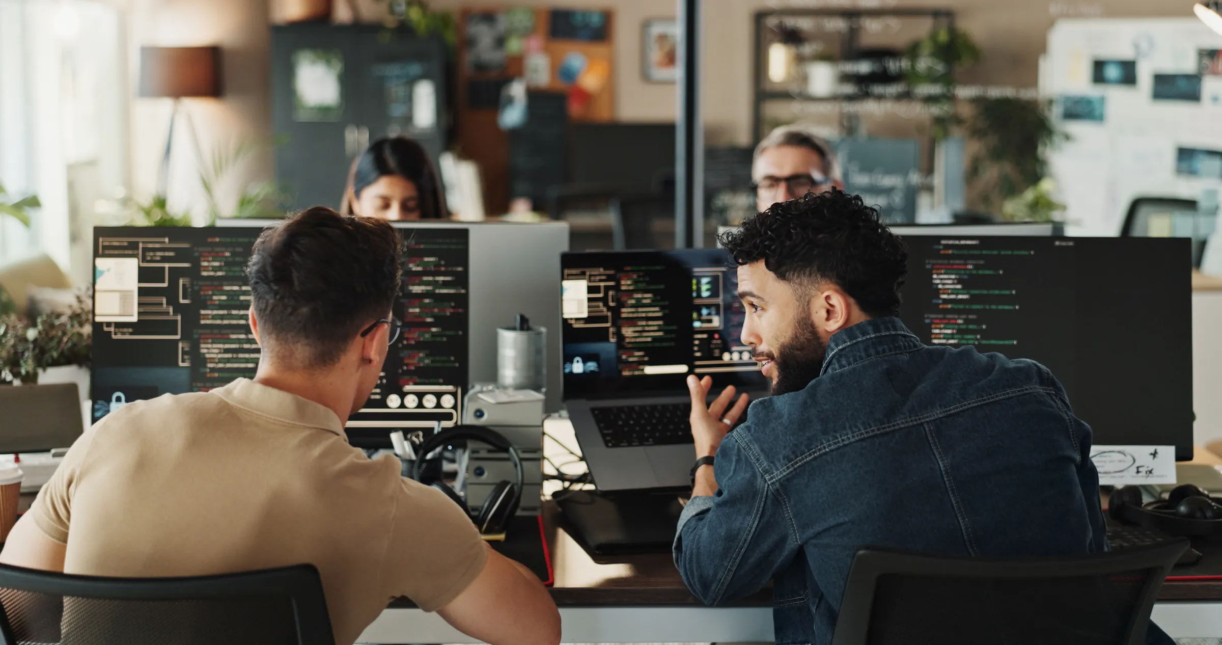 Engineers discussing code at their workstations