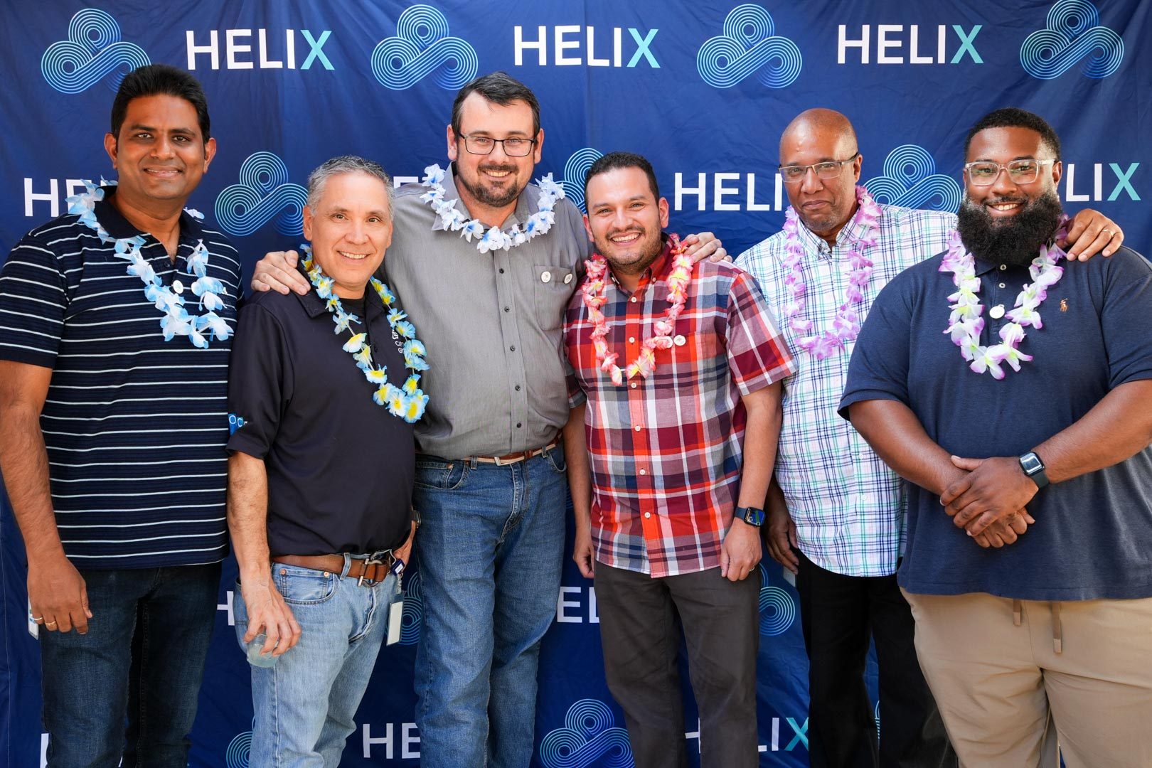 Team members celebrating a cloud migration milestone in front of a branded backdrop