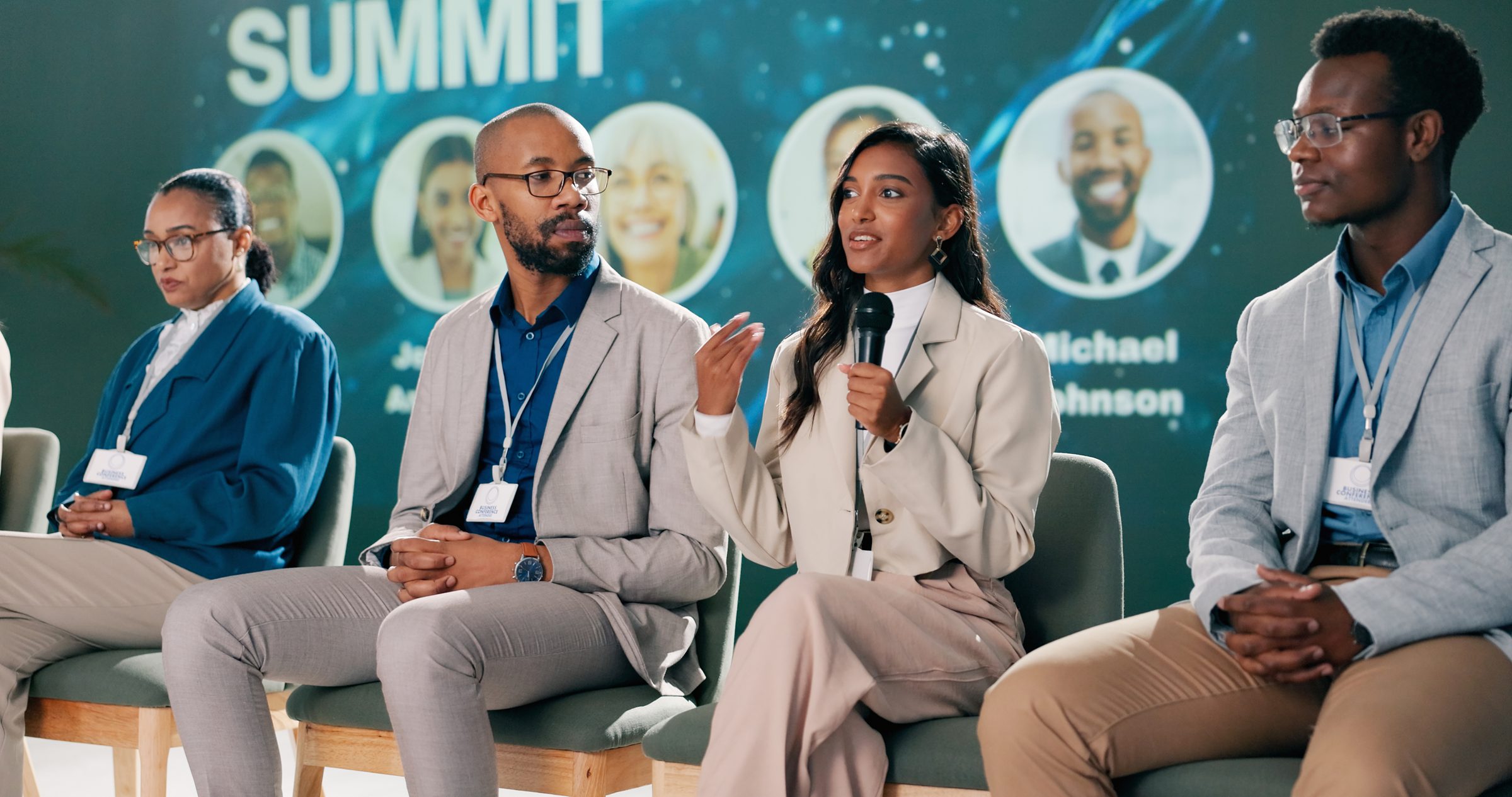 Panelists speaking on stage at a business summit