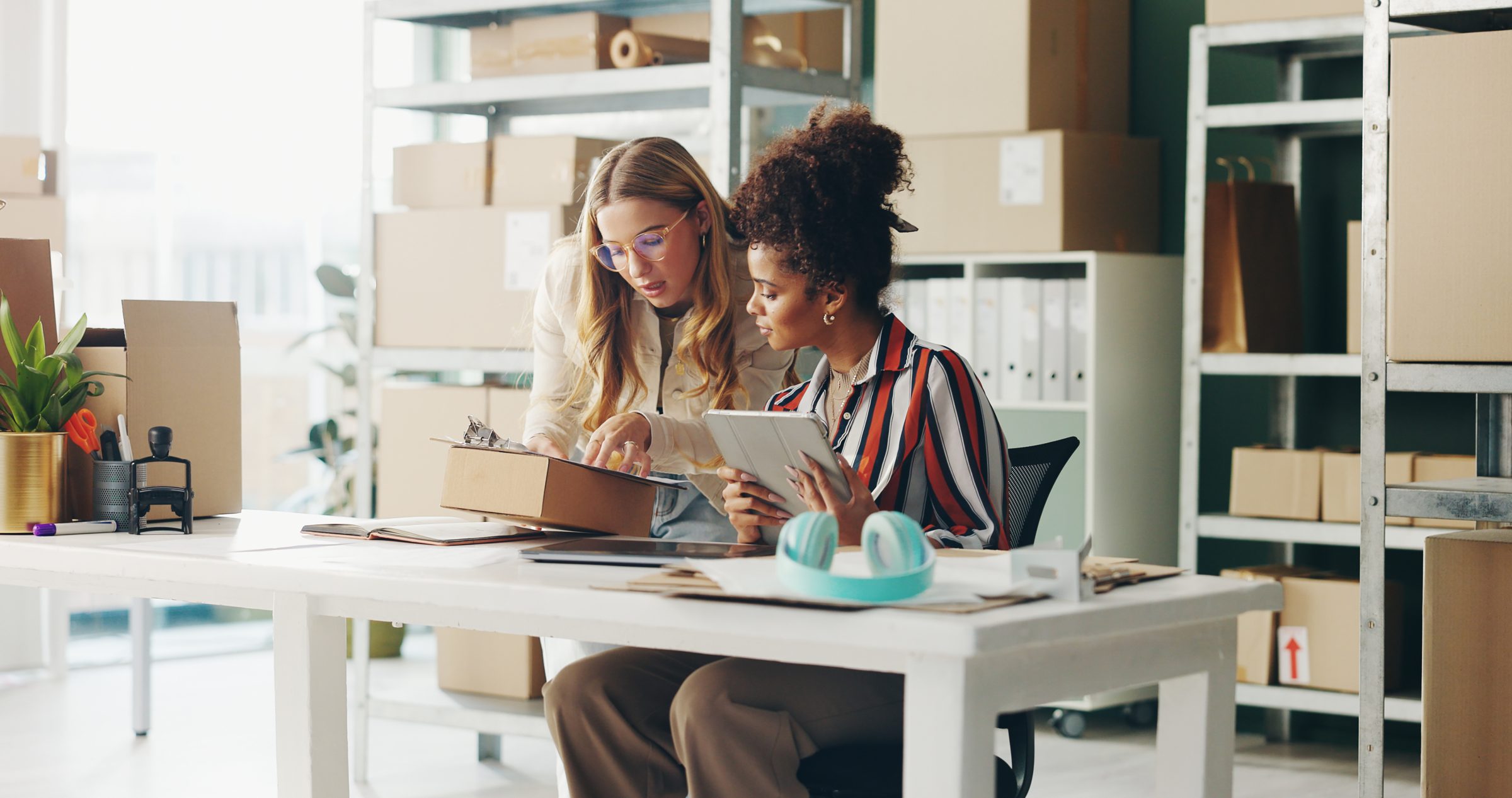 Two colleagues reviewing orders together in a stockroom office