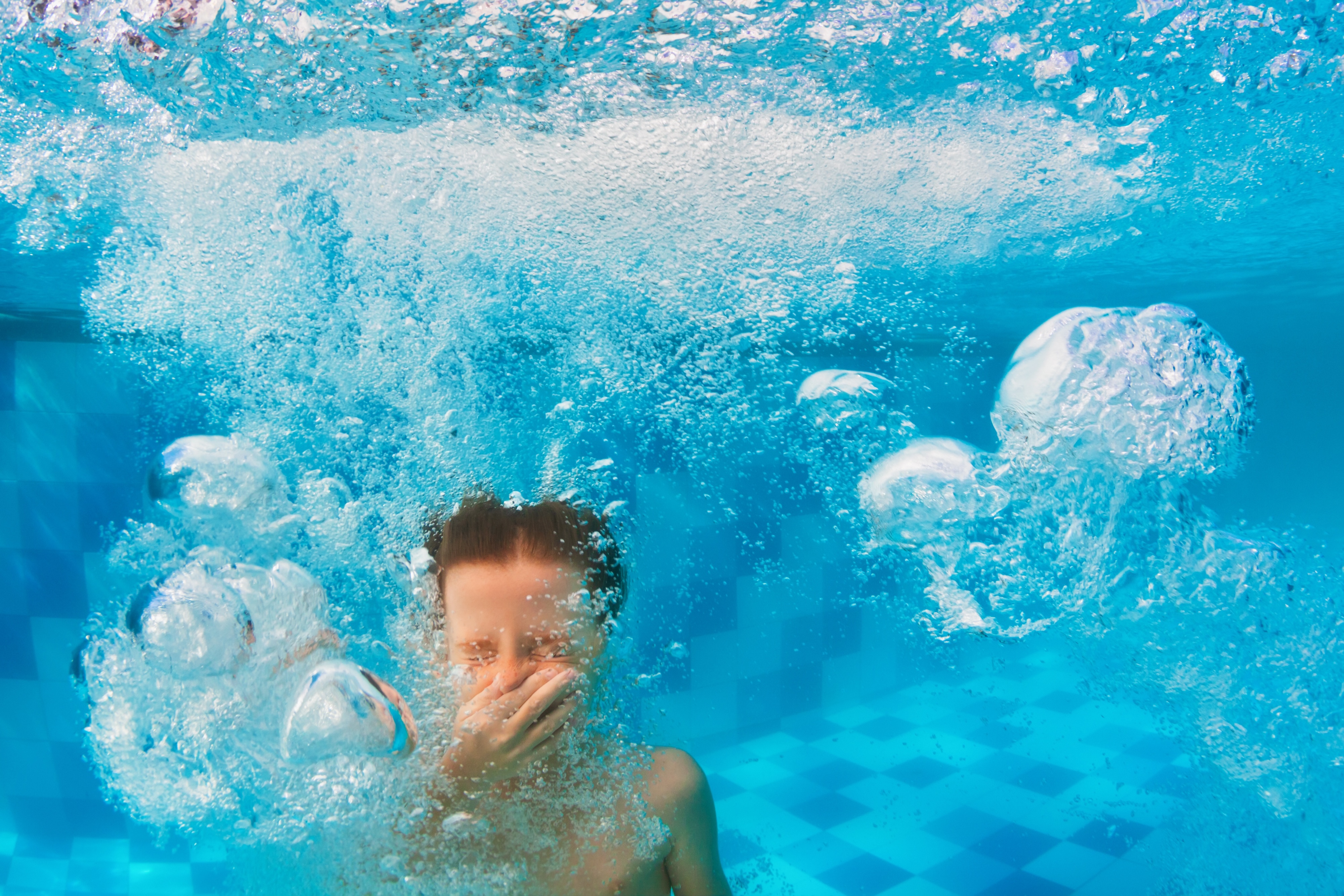 Child jumping in pool stock image