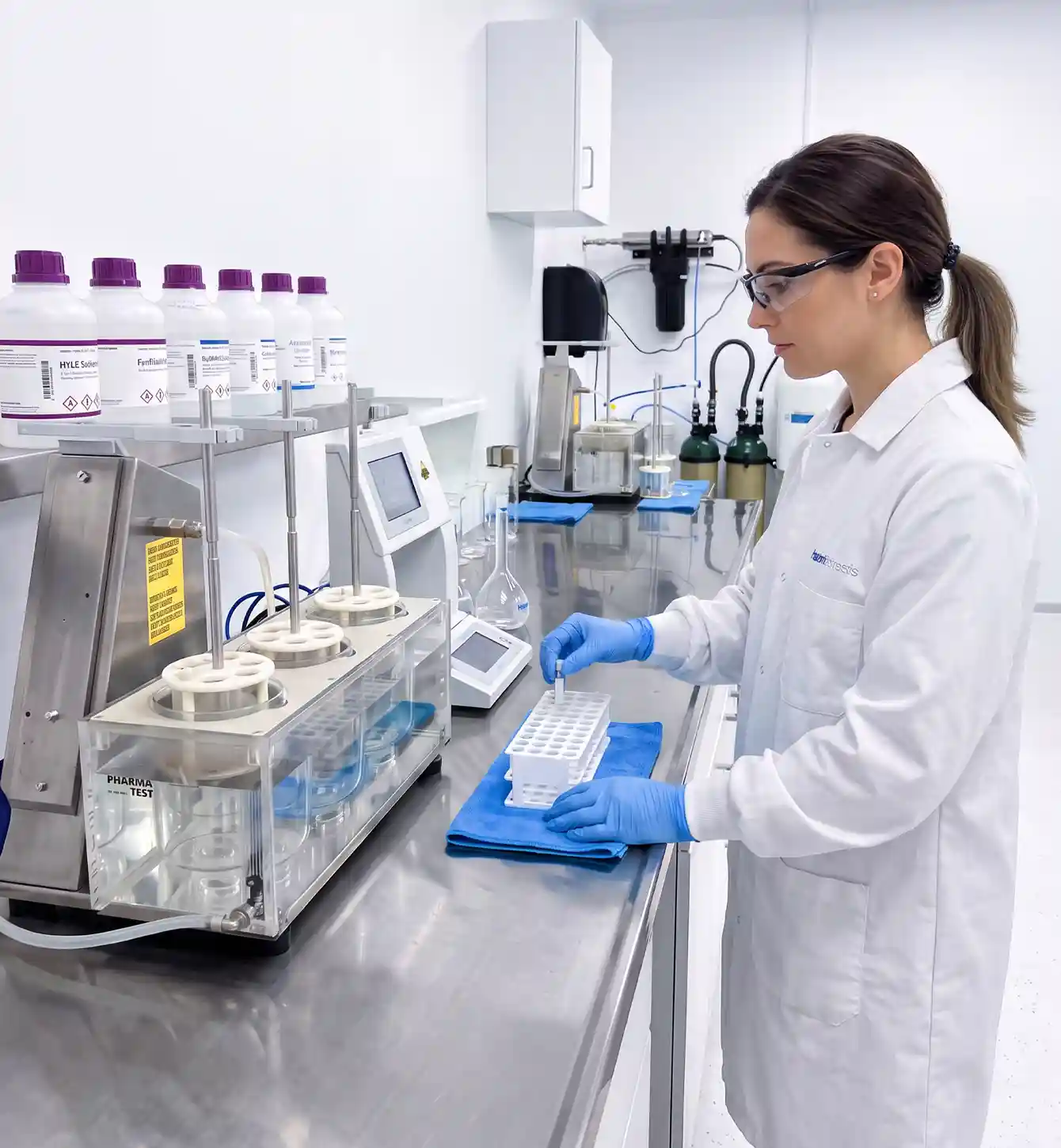 Laboratory technician operating testing equipment at a bench