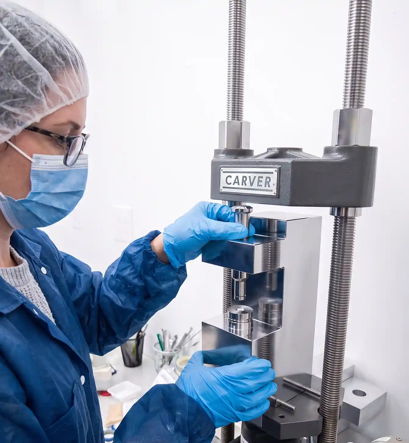 Technician operating a bench-top laboratory press
