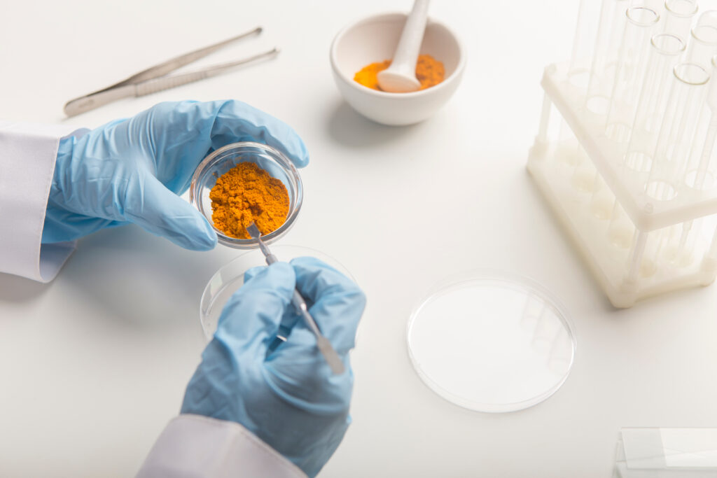 Curcumin supplement manufacturing facility showing capsule production line with quality control testing
