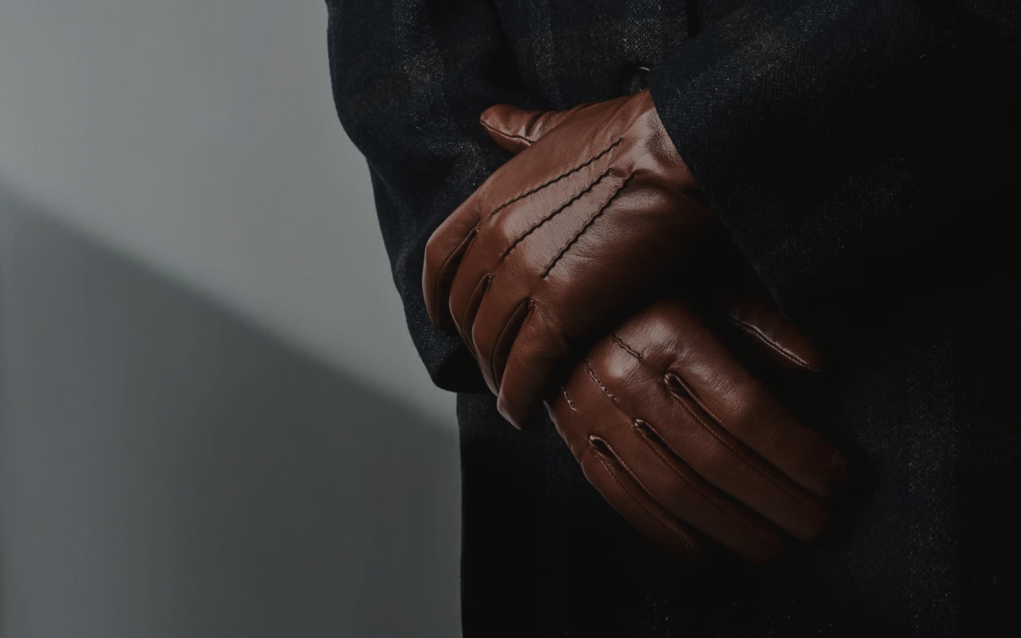 Man in a suit with leather gloves, arms crossed
