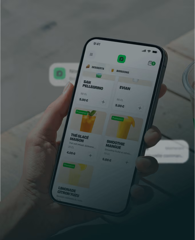 Main tenant un smartphone affichant un menu de boissons avec prix et promotions.