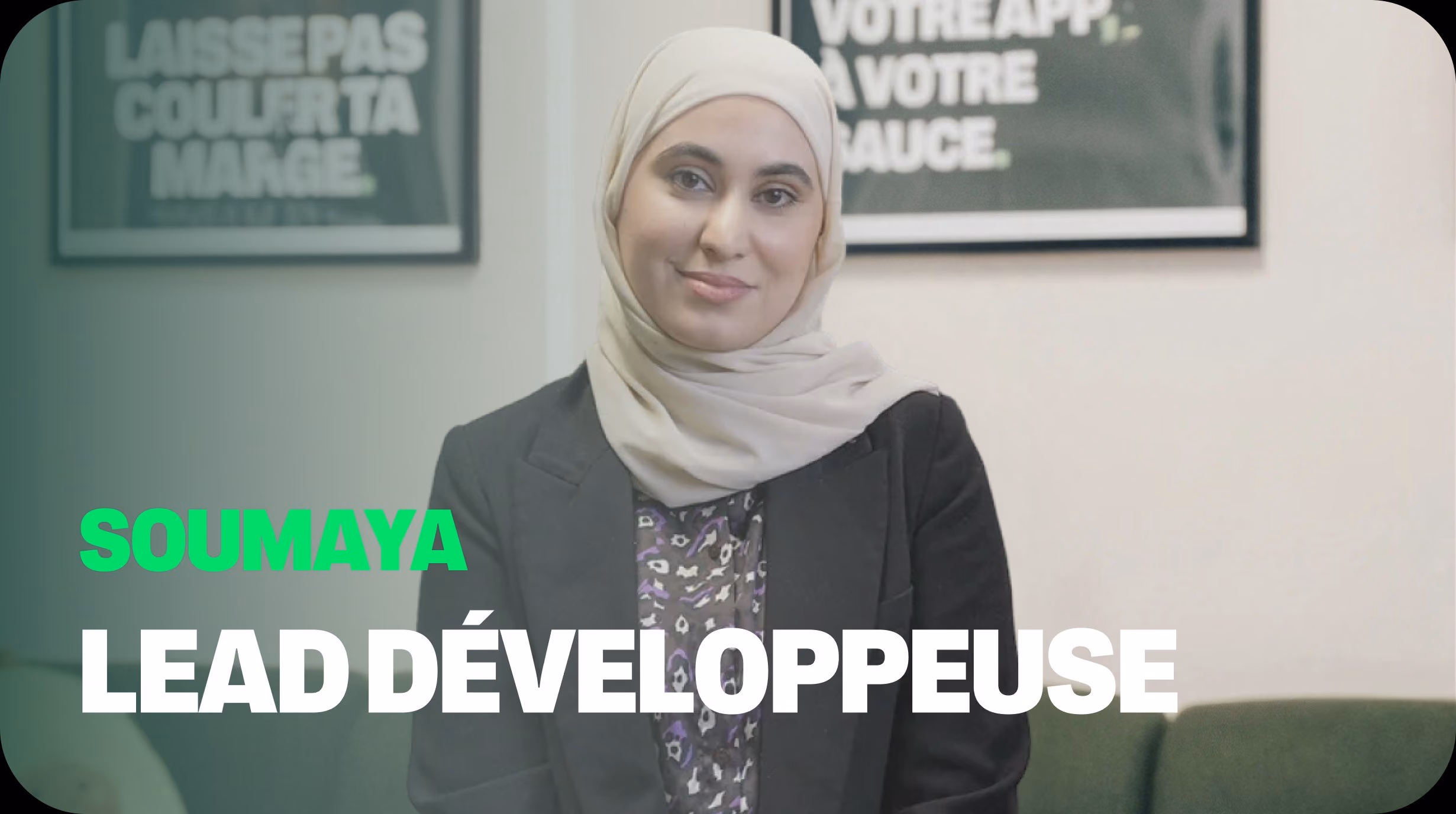 Portrait de Soumaya, Lead Développeuse chez Dishop, souriante dans un bureau avec des affiches sur la marque blanche et la rentabilité pour restaurateurs.