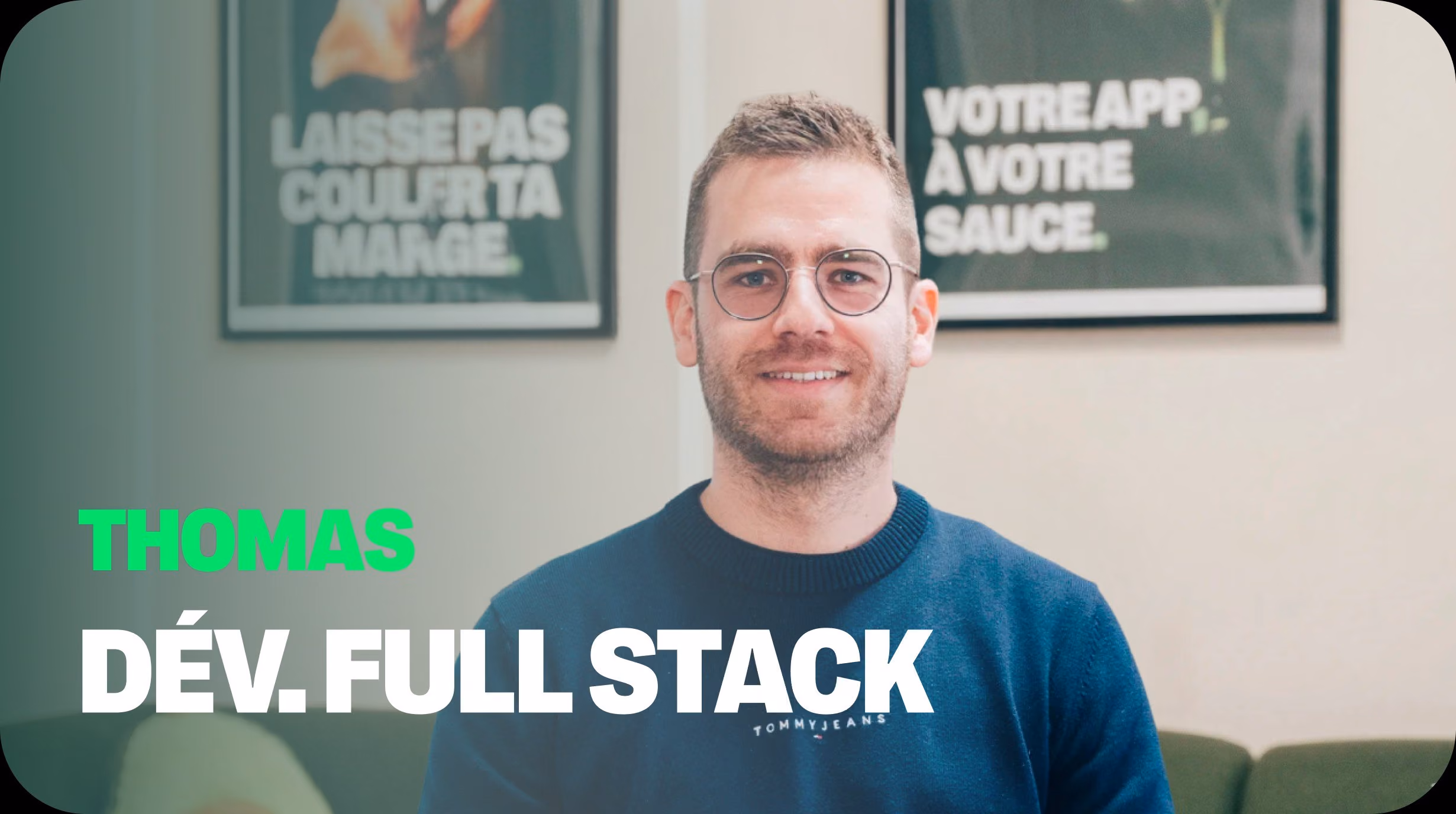 Portrait photographique de Thomas, développeur Full Stack chez Dishop, souriant devant des affiches promotionnelles pour la plateforme de commande directe en marque blanche