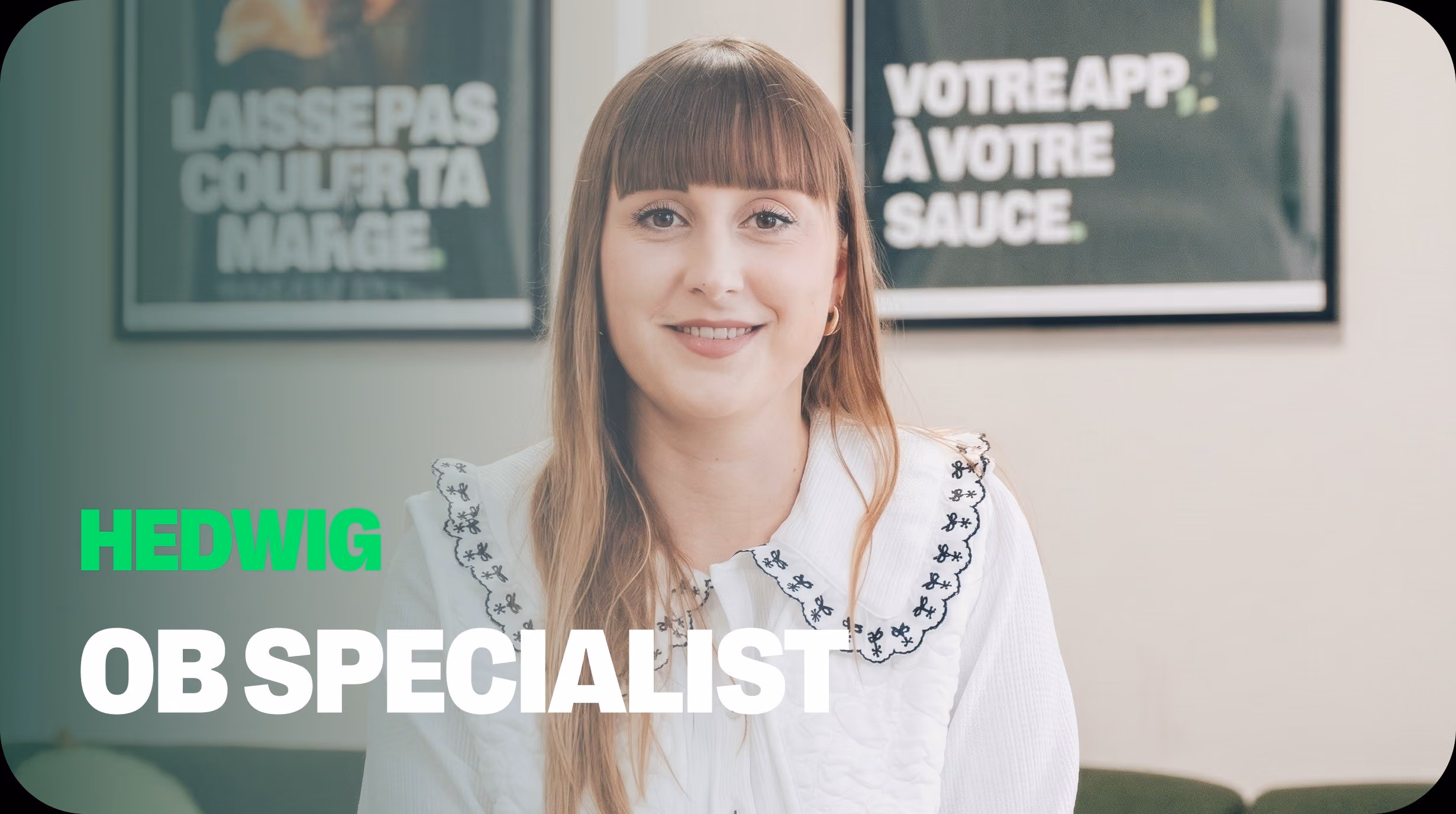 Hedwig, Onboarding Specialist chez Dishop, sourit devant deux affiches prônant l'indépendance des restaurateurs face aux plateformes de livraison