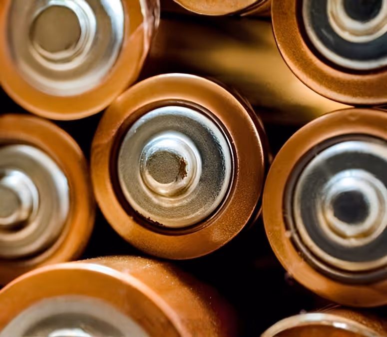 Close-up of several AA batteries showing their positive terminals.