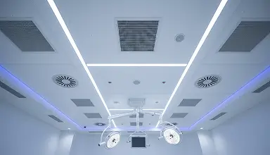 Hospital operating room ceiling with HVAC air diffusers and surgical lights