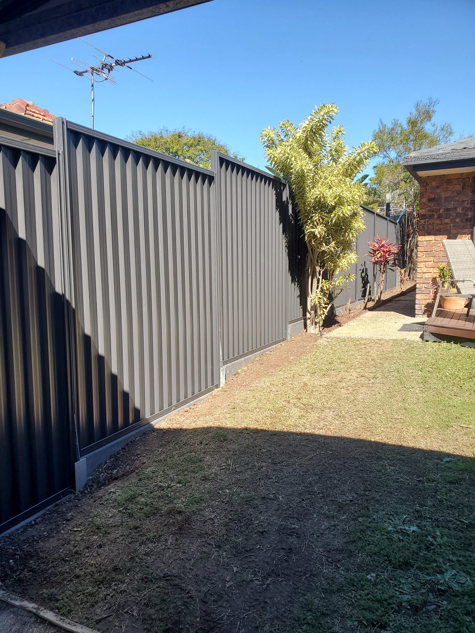 Black Colorbond steel fence with a clean, private finish, installed by Synergy Fencing in Brisbane