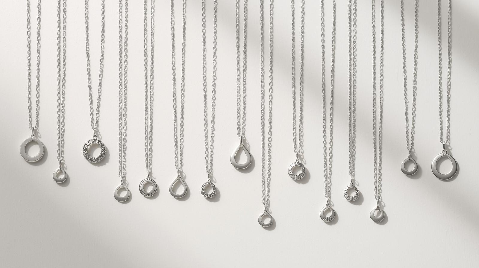 Different sterling silver necklace lengths with circular pendants displayed against a white background.