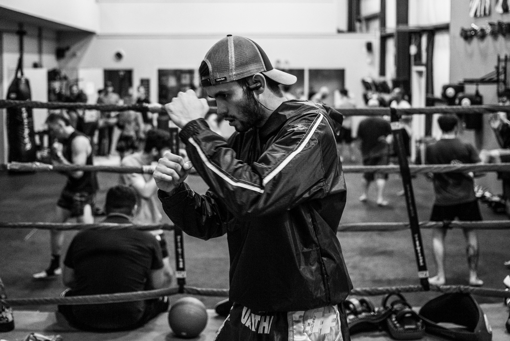 Muscular man boxing in the gym with a bold necklace
