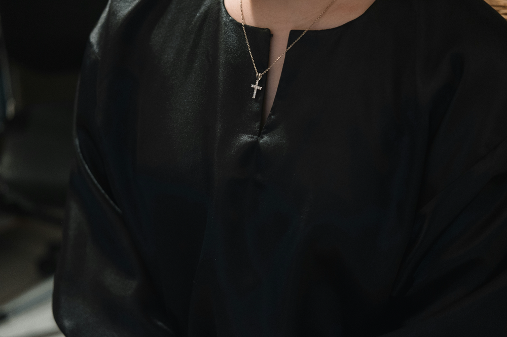 A man showing off a Silver Cross Jewelry Necklace
