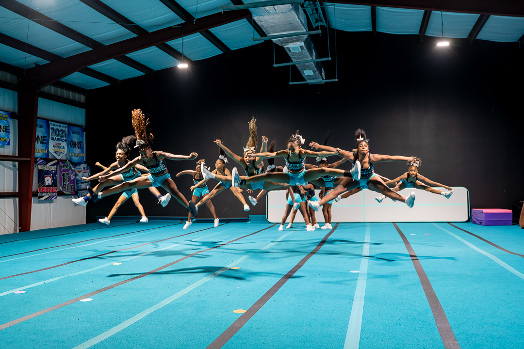 Hailstorm Cheer athletes performing a synchronized jump in the gym